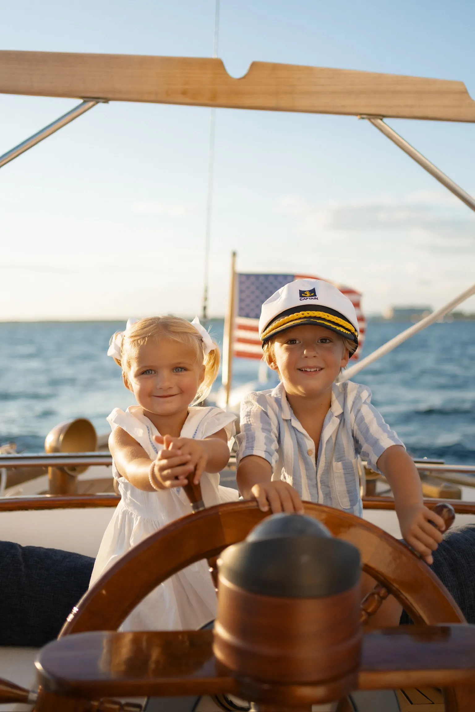 Two children taking a turn at the ship’s wheel