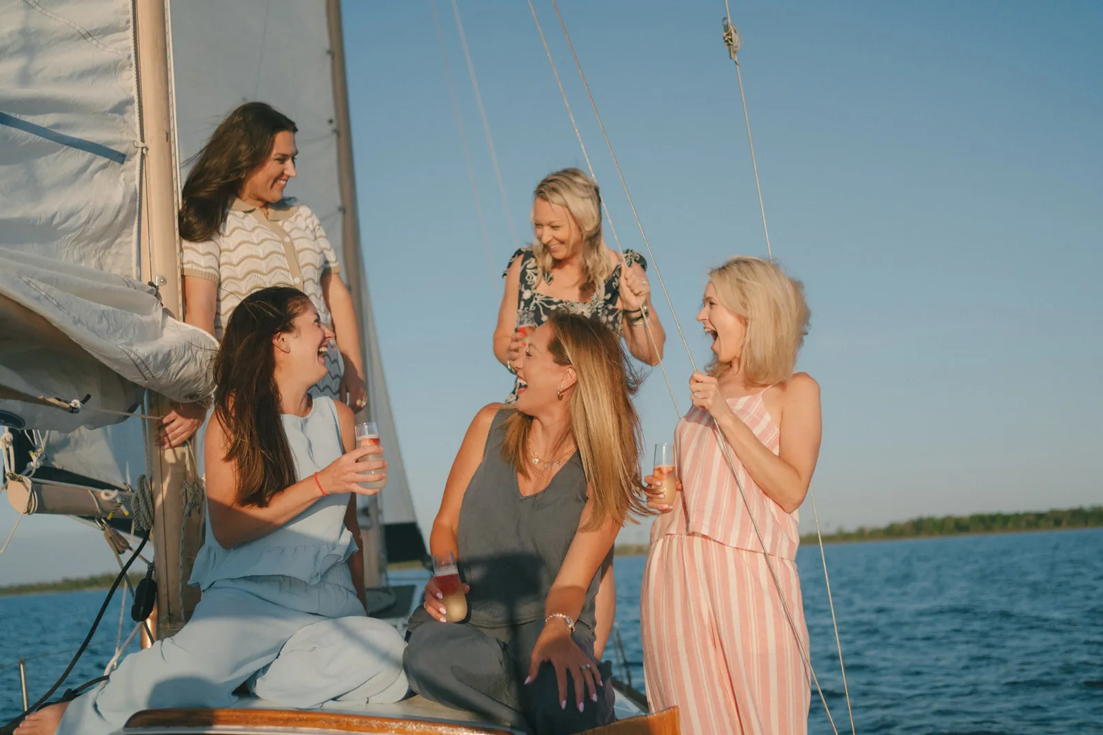 A group of friends laughing on deck during golden hour