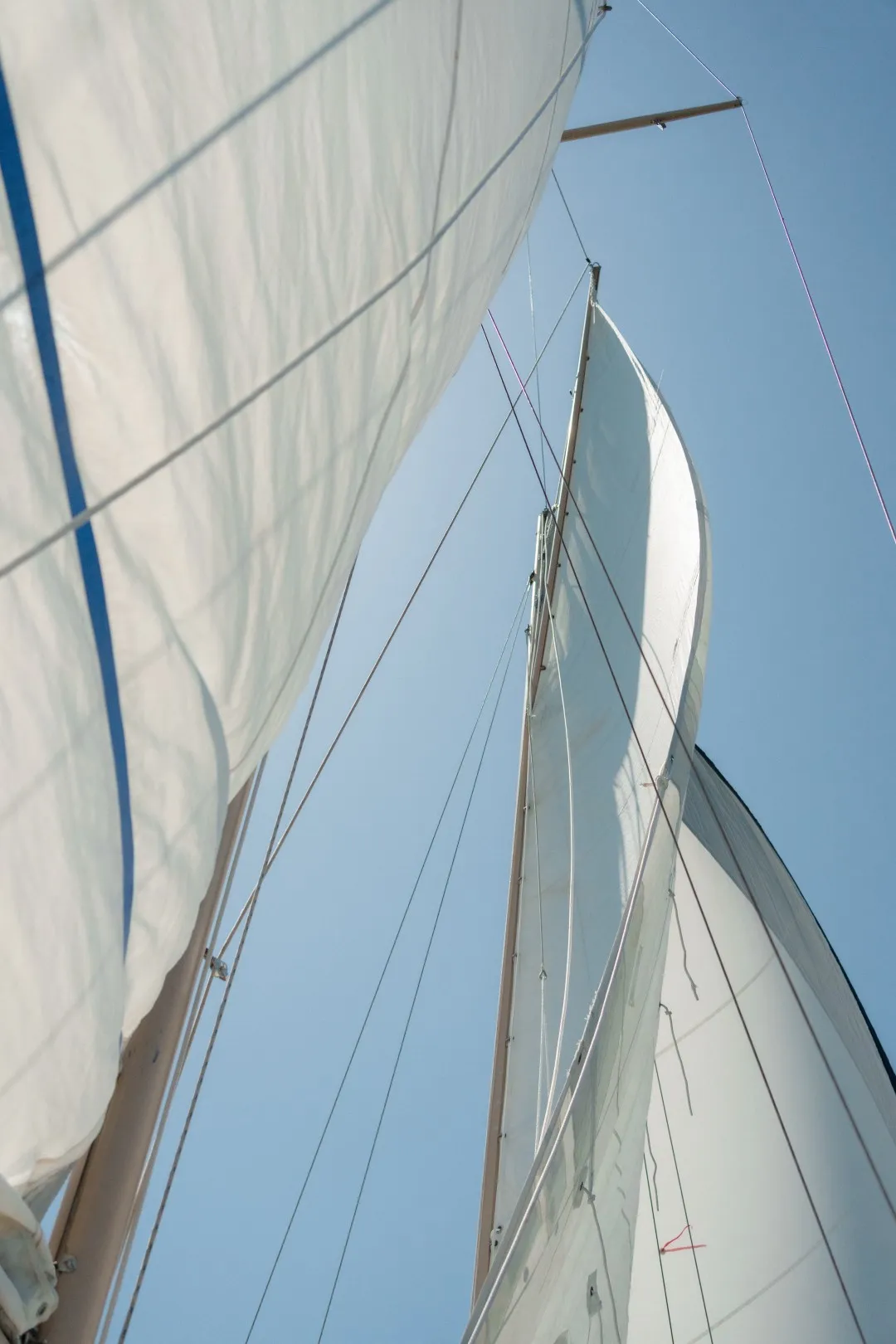 Looking up at the mainsail against a clear sky